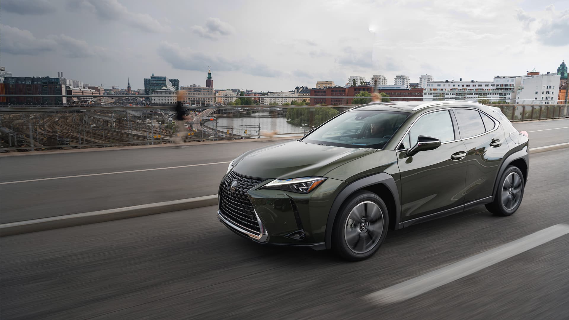 Dark green Lexus UX driving up a mountain.